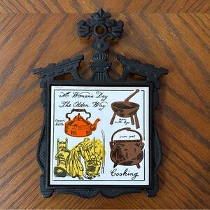 Vintage 1960/70s Cast Iron “A Woman Day The Olden Way” Ceramic Trivet Black